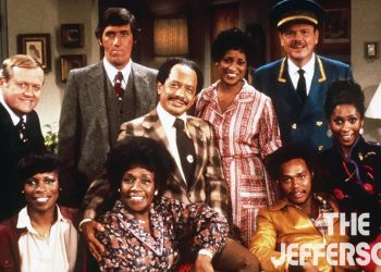The main cast of "The Jeffersons" posing together in a living room setting.