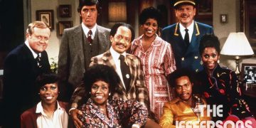 The main cast of "The Jeffersons" posing together in a living room setting.