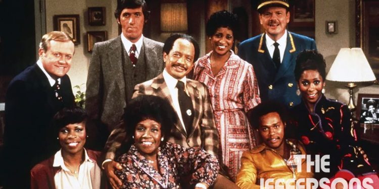 The main cast of "The Jeffersons" posing together in a living room setting.