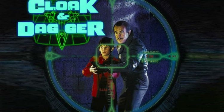 Box artwork for the 1984 movie "Cloak & Dagger" featuring a young boy and an older man in a targeting scope.