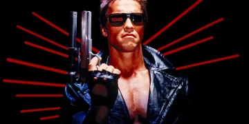 Man in leather jacket with sunglasses and shotgun.