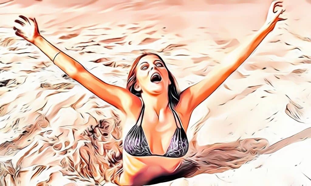 Woman in black bikini arms raised, sandy background.