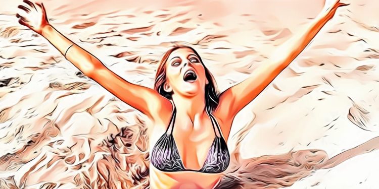 Woman in black bikini arms raised, sandy background.